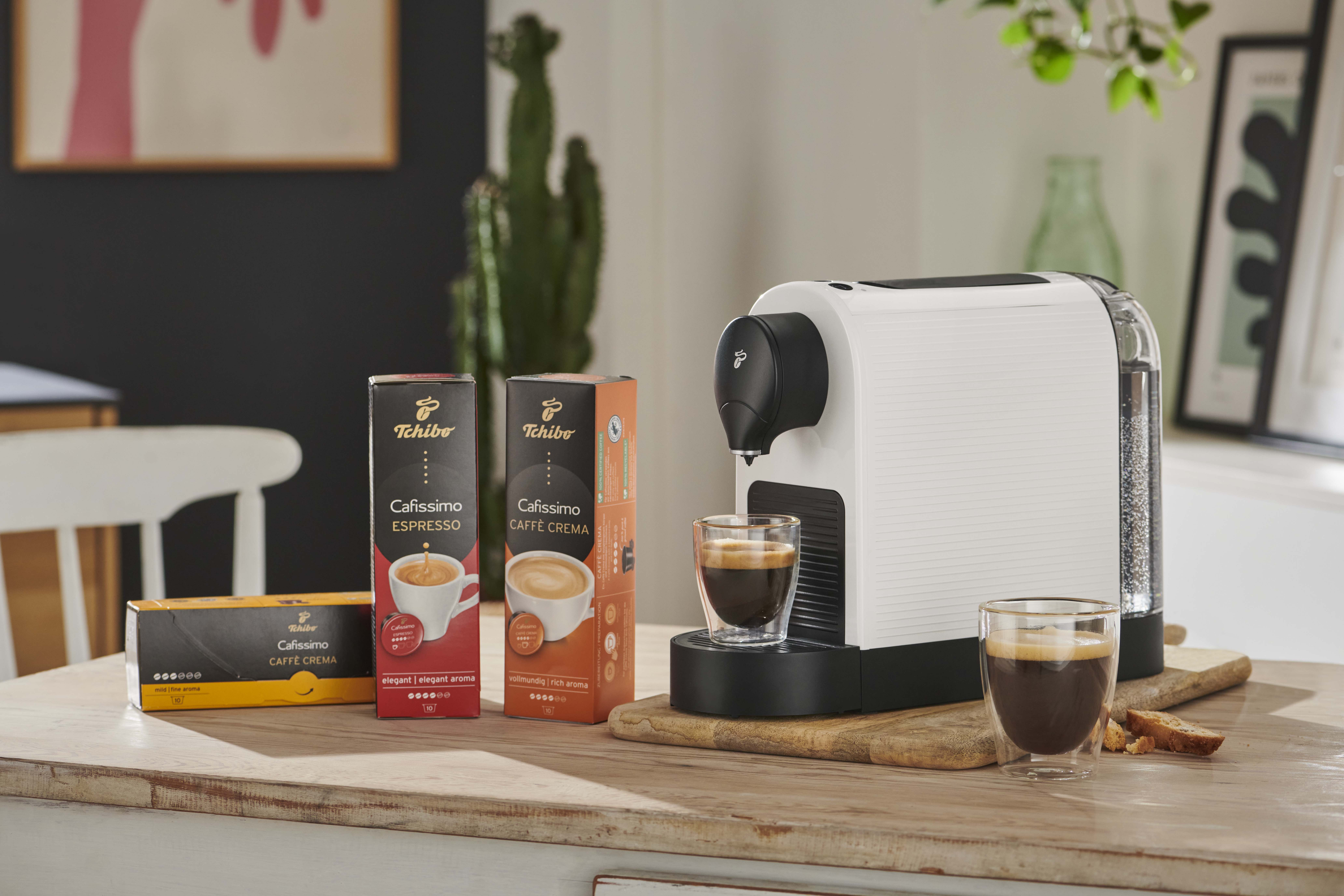 İki kahve bardağı ve kahve kutuları ile espresso makinesi.