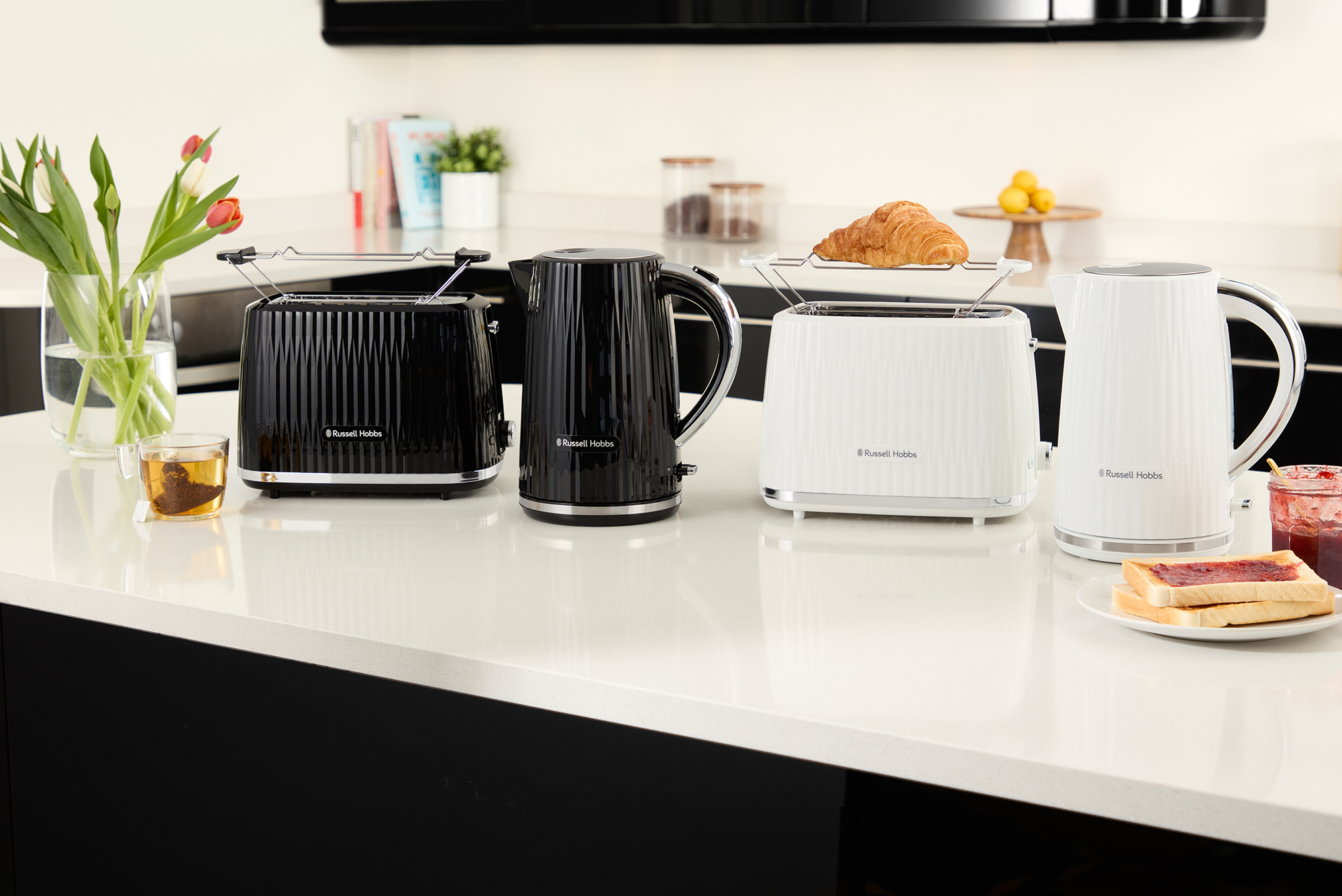 Fekete-fehér Russell Hobbs kenyérpirítók és vízforraló. Fehér pult.