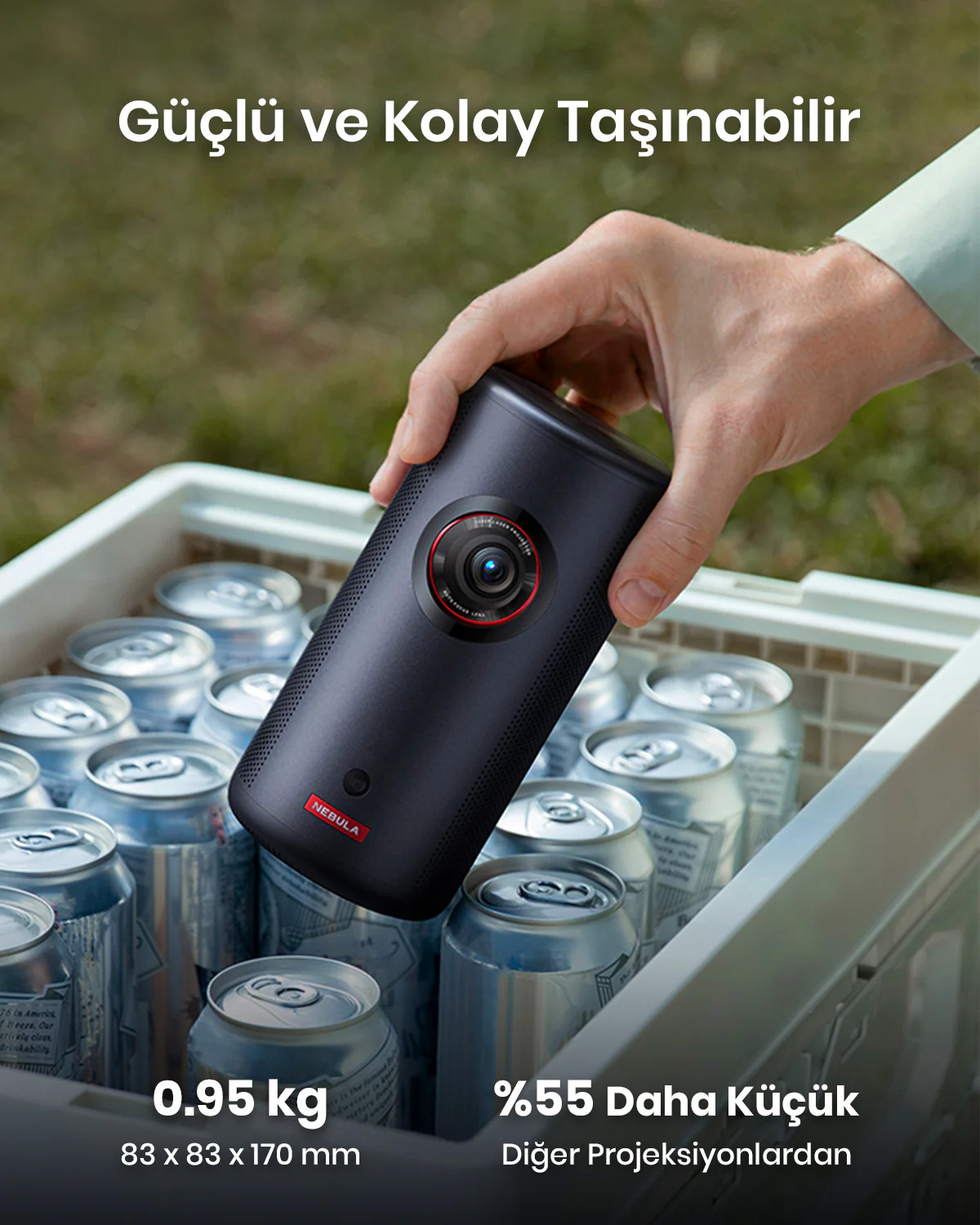Siyah bir Nebula projektörünü, teneke kutularla dolu beyaz bir sandığı ve metni tutan bir el.