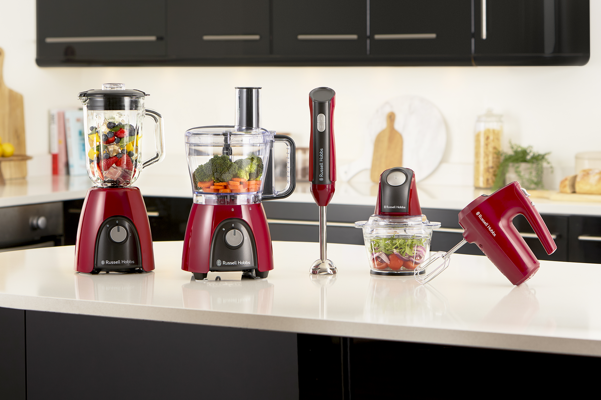 Piros Russell Hobbs konyhai eszközök fehér pulton. Fekete háttér.