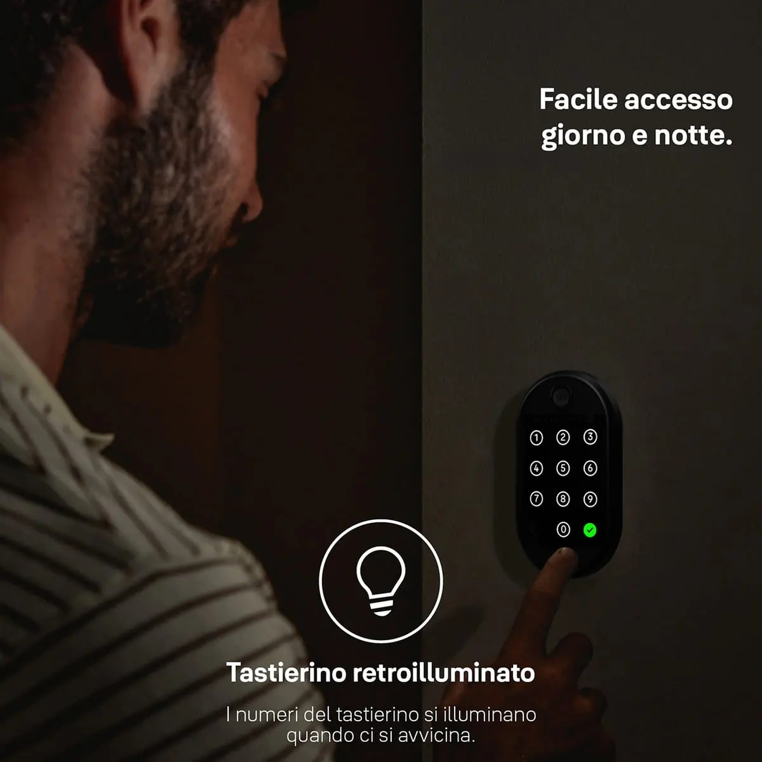 Una persona indica una tastiera nera illuminata su un muro. Testo in italiano.
