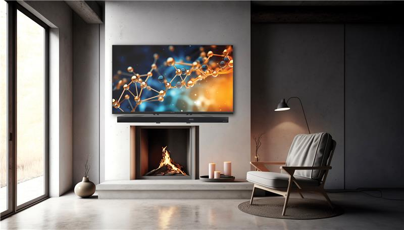 Ein Wohnzimmer mit einem Fernseher über einem Kamin, einer Soundbar und einem Stuhl. Der Fernseher zeigt ein Molekülbild.