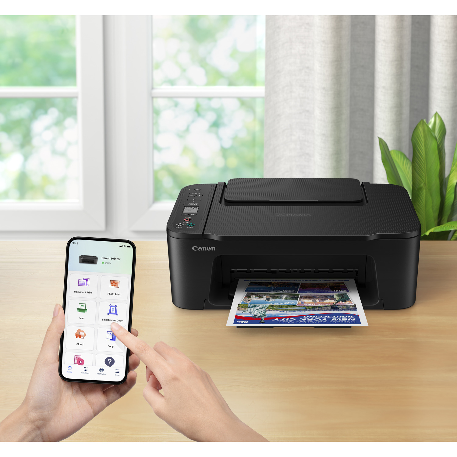 Black Canon printer with paper outputting a document. A hand holding a phone with app screen is visible.