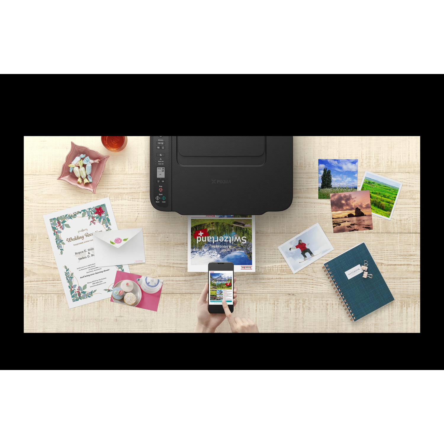 A printer printing a magazine cover. Surrounded by photos, a phone, and stationery.