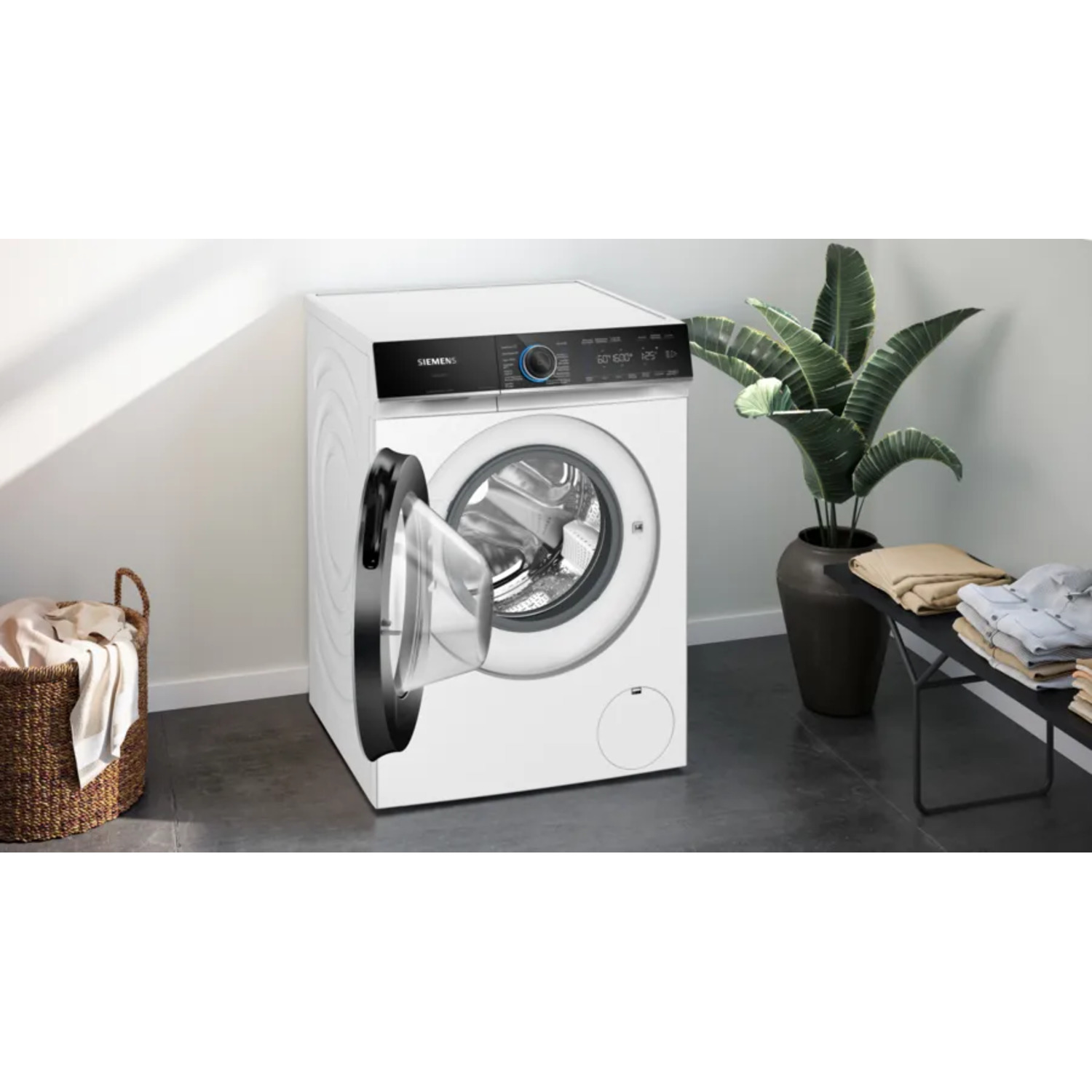 White washing machine with open door, basket, and a plant in the background.