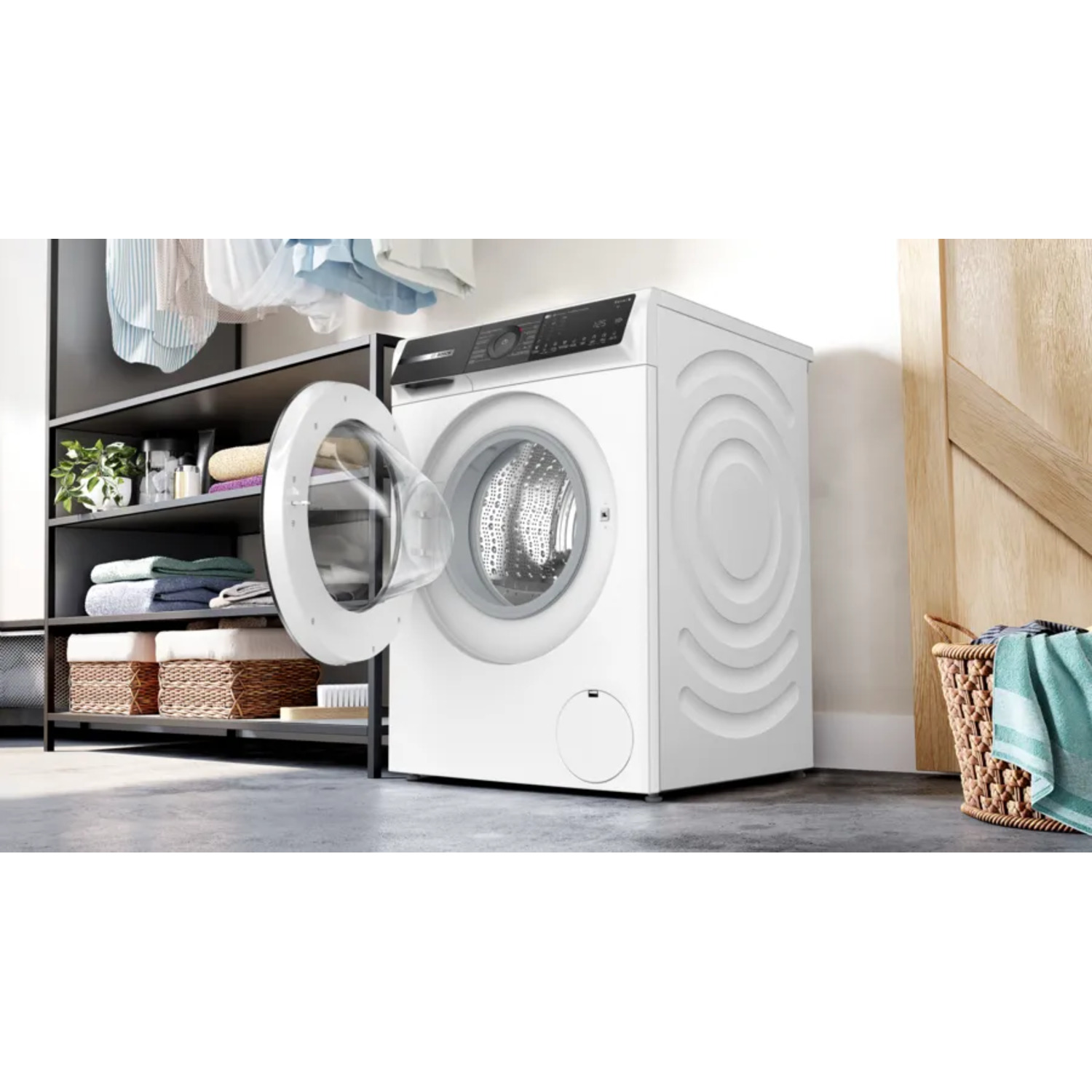 Witte wasmachine met open deur, in een wasruimte met wasgoed.