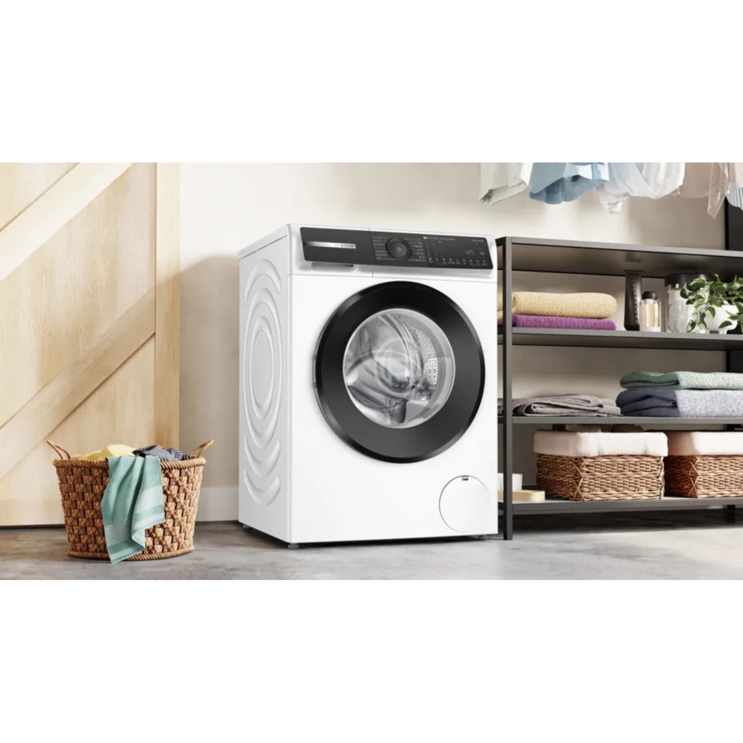 Witte wasmachine met een zwarte deur en bedieningspaneel. Wasmand in de buurt.