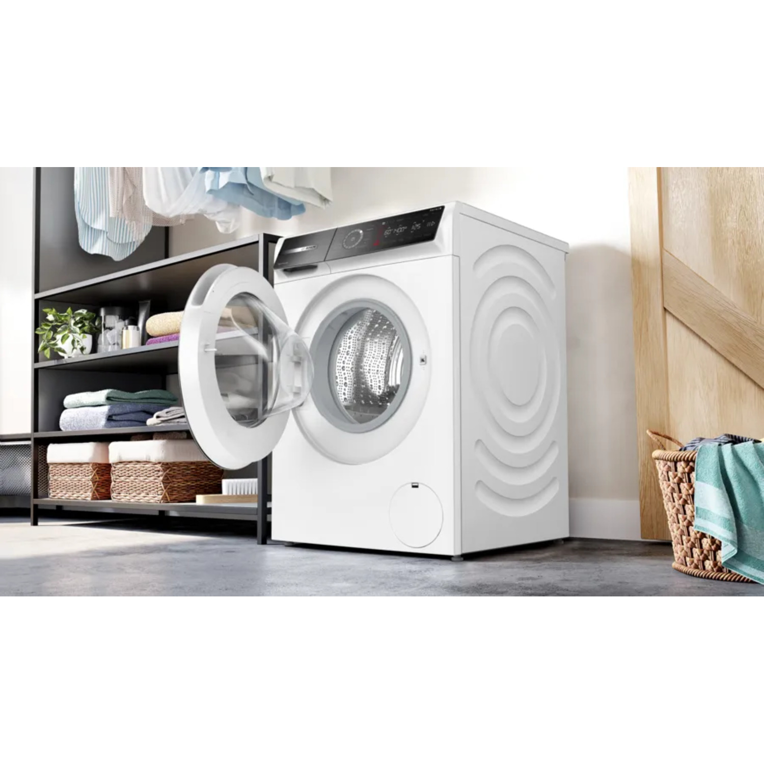 Witte wasmachine met open deur. Wasgoed op planken en in mand in de buurt.