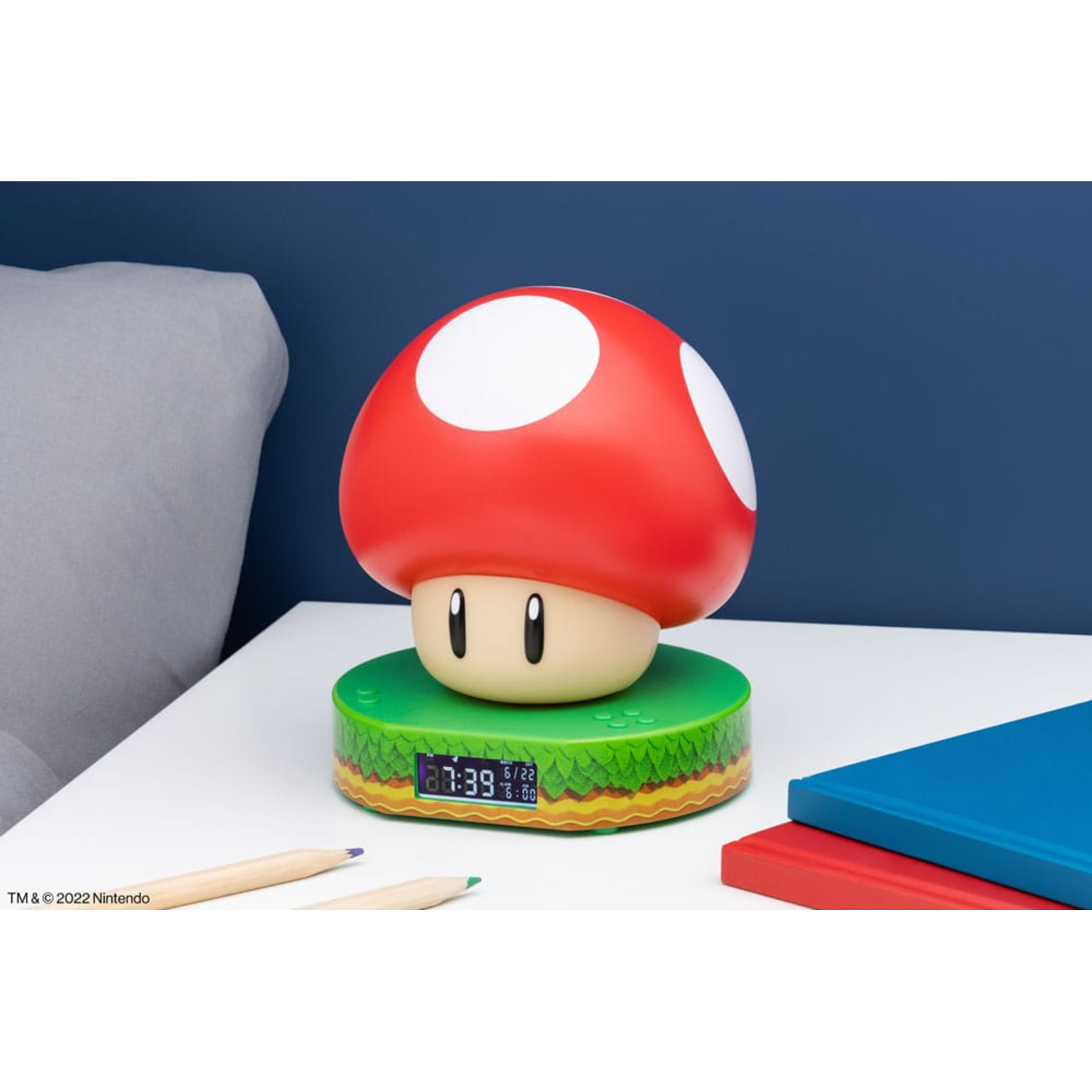 A Mario mushroom-shaped alarm clock on a green platform with a digital display.