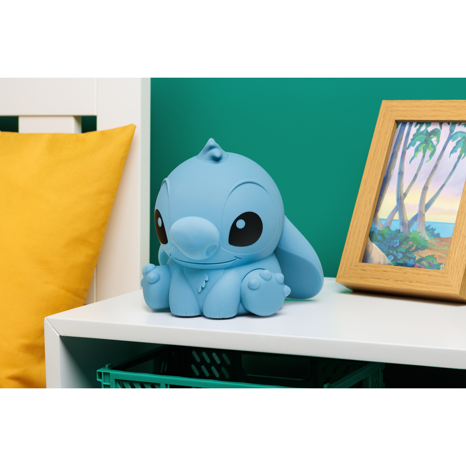 Blue Stitch figure on a white surface. A yellow pillow is in the background.
