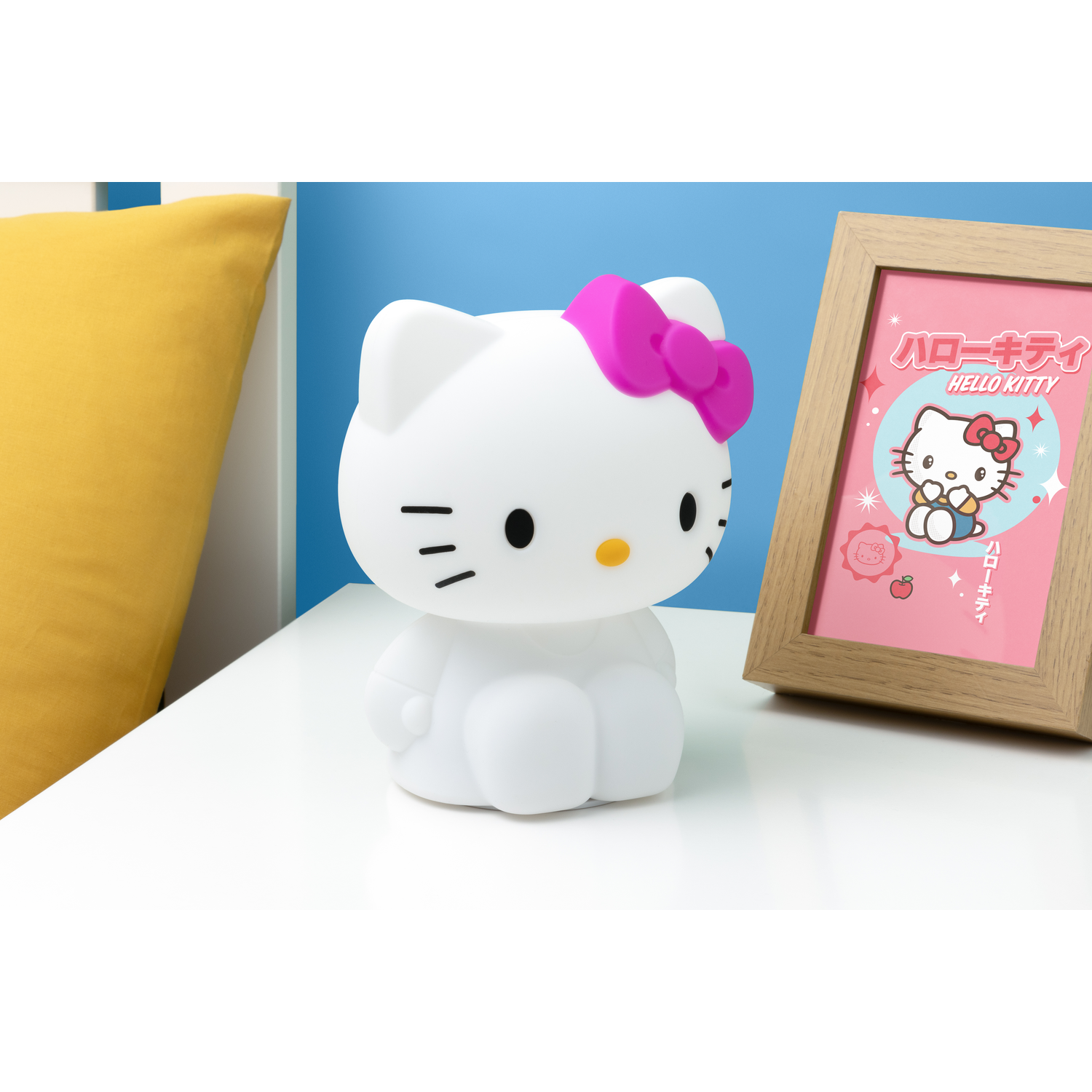 Hello Kitty lamp with a pink bow and a framed picture of Hello Kitty.