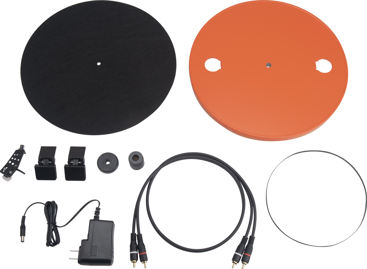 Pièces de platine vinyle. Deux disques noirs et oranges. Câbles, adaptateur et autres accessoires.