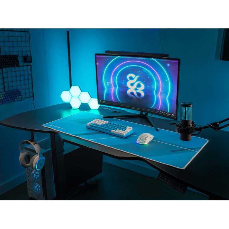Configuración de juegos con monitor, teclado, ratón, auriculares y micrófono en un escritorio.