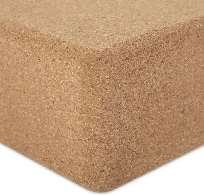 Kwadratowy brązowy klocek do jogi z korka. Klocek ma naturalną fakturę korka.