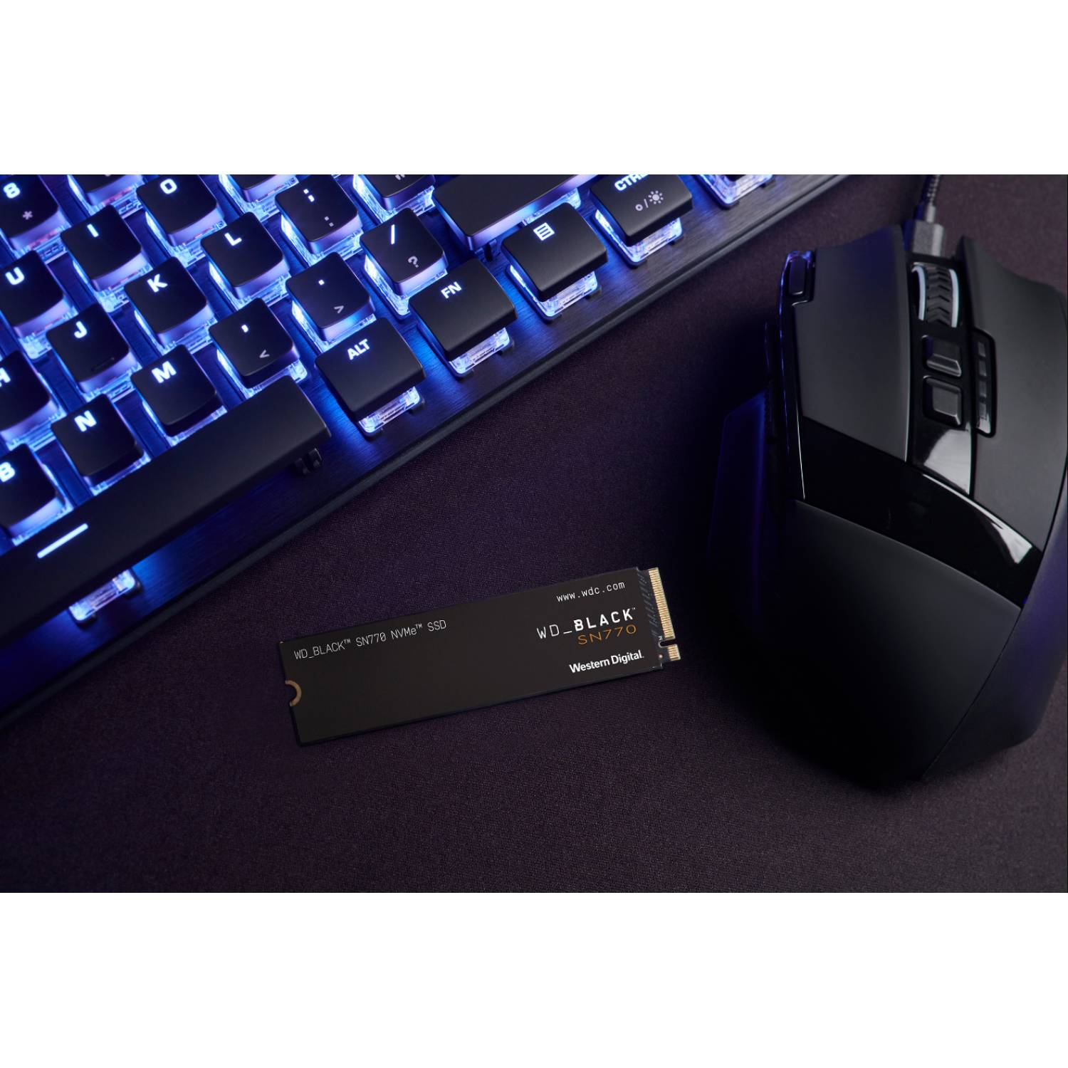 Un teclado negro, un ratón negro y una SSD WD_BLACK SN770 NVMe.