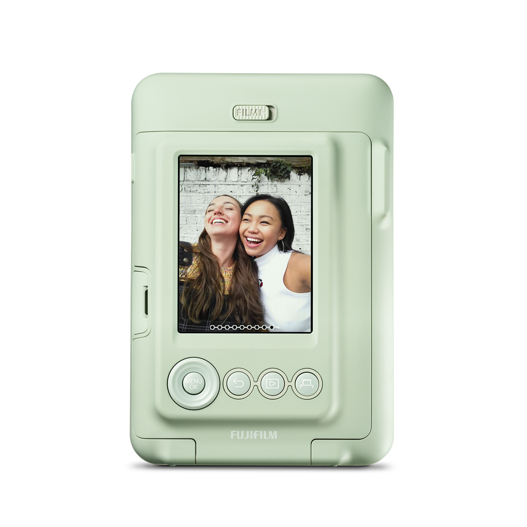 Açık yeşil anında fotoğraf makinesi, iki gülümseyen kadının fotoğrafını gösteriyor. Fujifilm logosu.