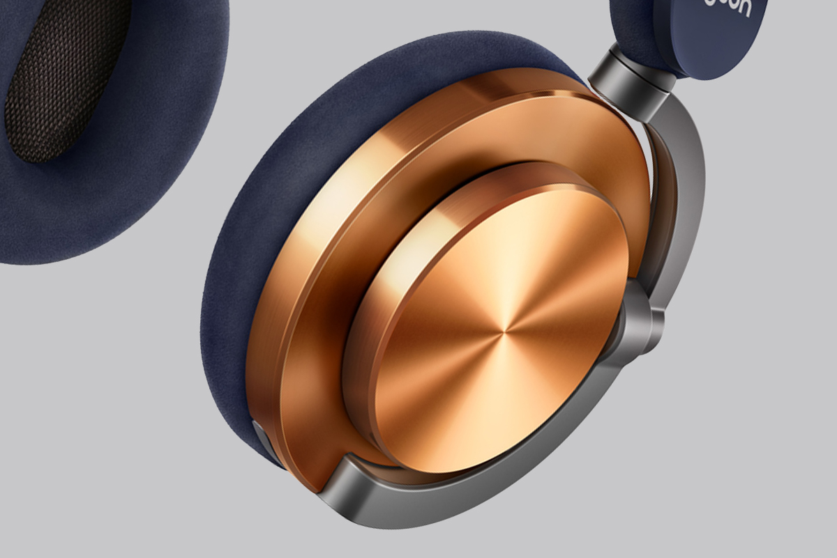 Primer plano de un par de auriculares. Los auriculares son azul oscuro y el metal dorado y plateado.