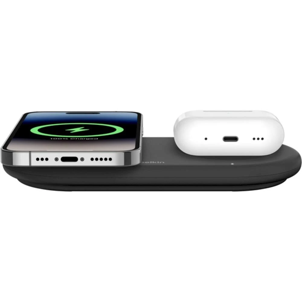 Base de carga negra con un teléfono y auriculares. El teléfono se está cargando.