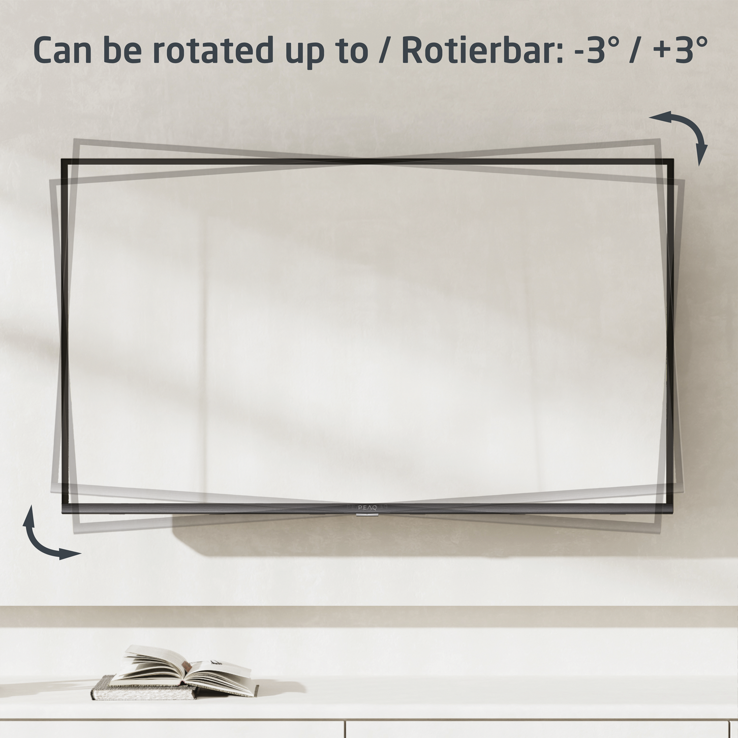 Pantalla de TV en pared, con indicadores de rotación y un libro en una superficie blanca.
