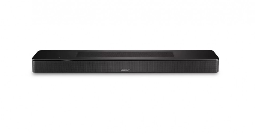 Una barra de sonido negra con la marca Bose. La barra de sonido está sobre una superficie blanca.