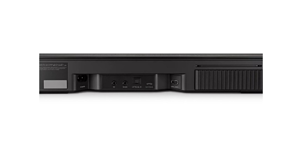Parte trasera de barra de sonido negra con puertos. Fondo blanco.