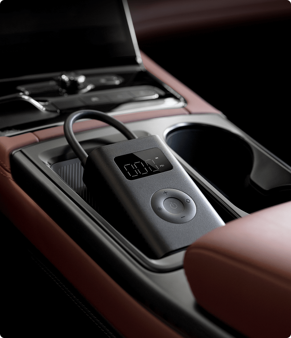 Gonfiatore per pneumatici portatile grigio all'interno della console dell'auto, con display digitale.