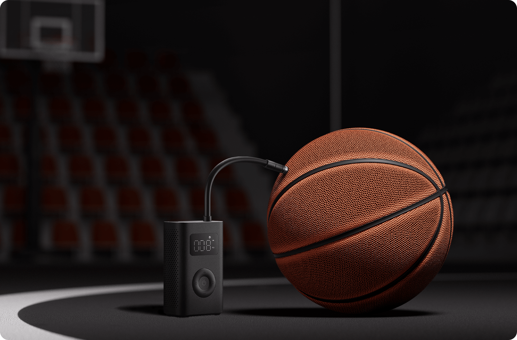 Un pallone da basket viene gonfiato su un campo. Una pompa è collegata alla palla. Sfondo sfocato.