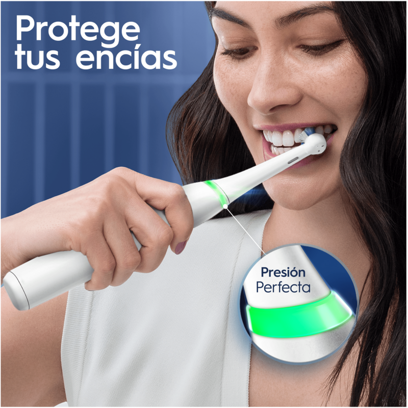 Mujer cepillándose los dientes con un cepillo eléctrico. El cepillo tiene una luz verde.