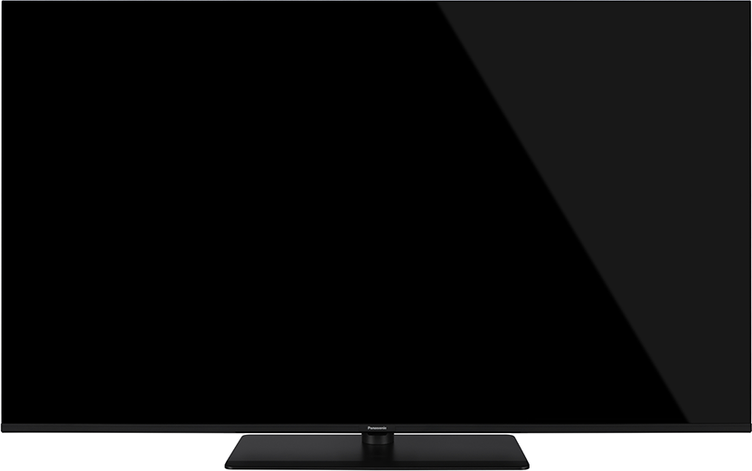 Egy nagy, fekete, téglalap alakú TV fekete állványon. A képernyő ki van kapcsolva, tükrözi a szobát. Fekete háttér.