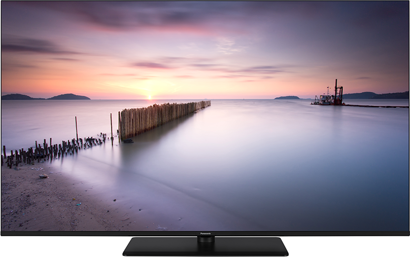 Egy TV képernyő naplementés tengerparti jelenetet mutat fa kerítéssel.