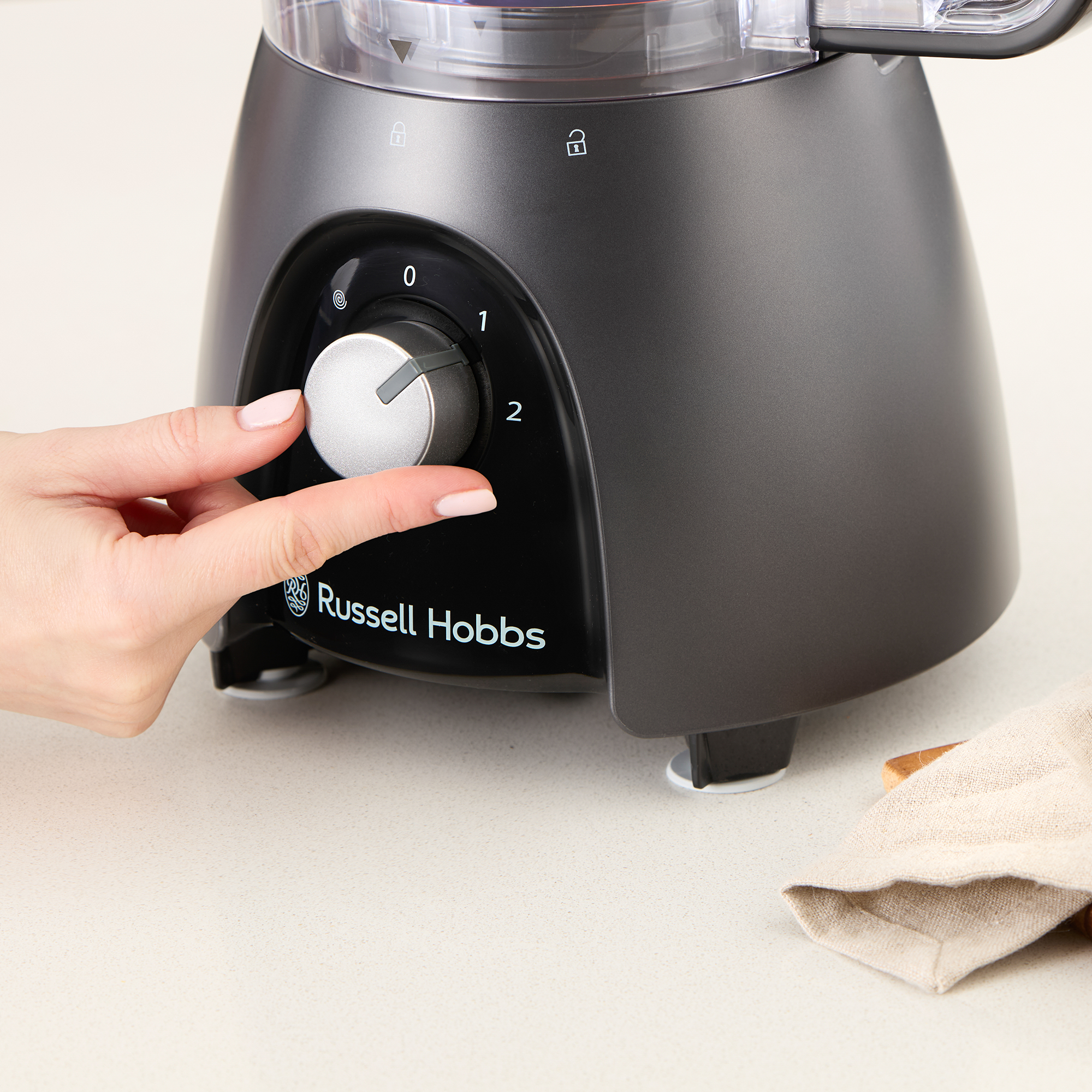 Egy kéz forgatja a Russell Hobbs konyhai robotgép tárcsáját, 0-ra állítva.