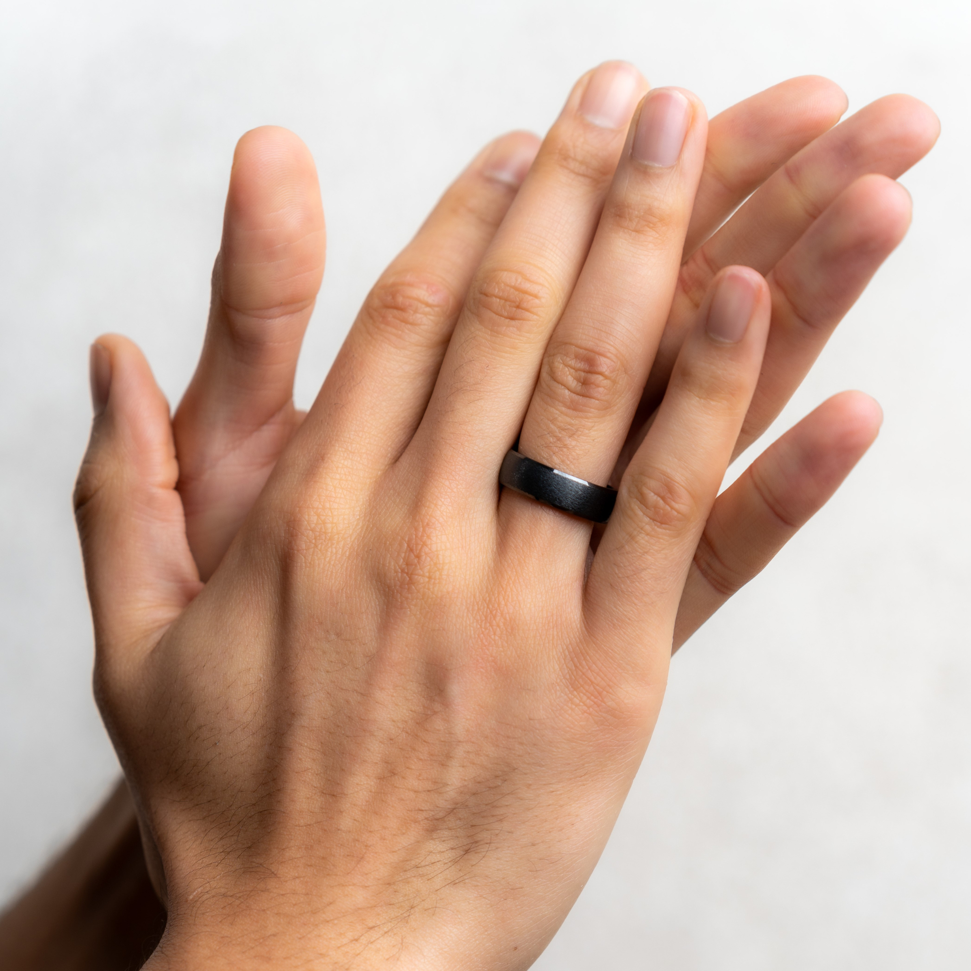 Die Hände einer Person, eine mit einem schwarzen Ring, klatschen.