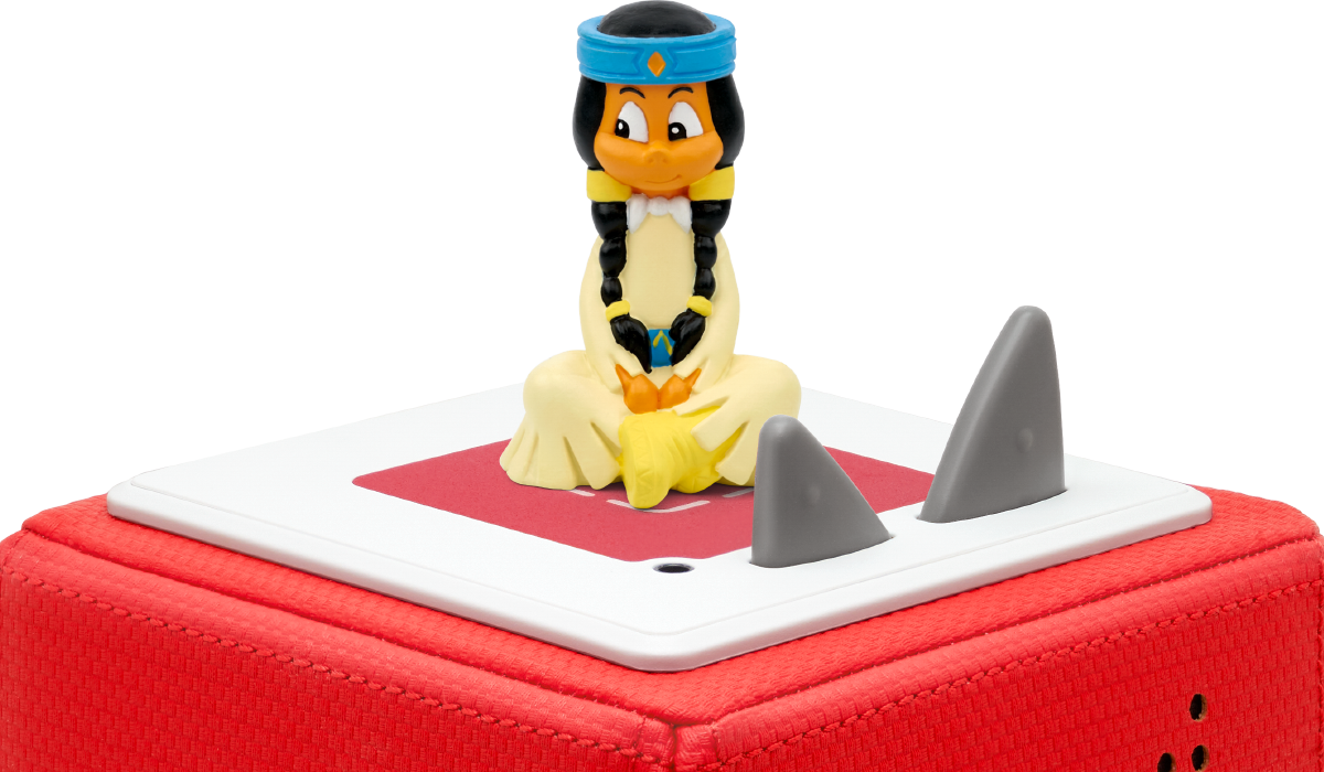 Une figurine de jouet d'un Amérindien de dessin animé est assise sur une boîte à jouets rouge avec des ailerons de requin.