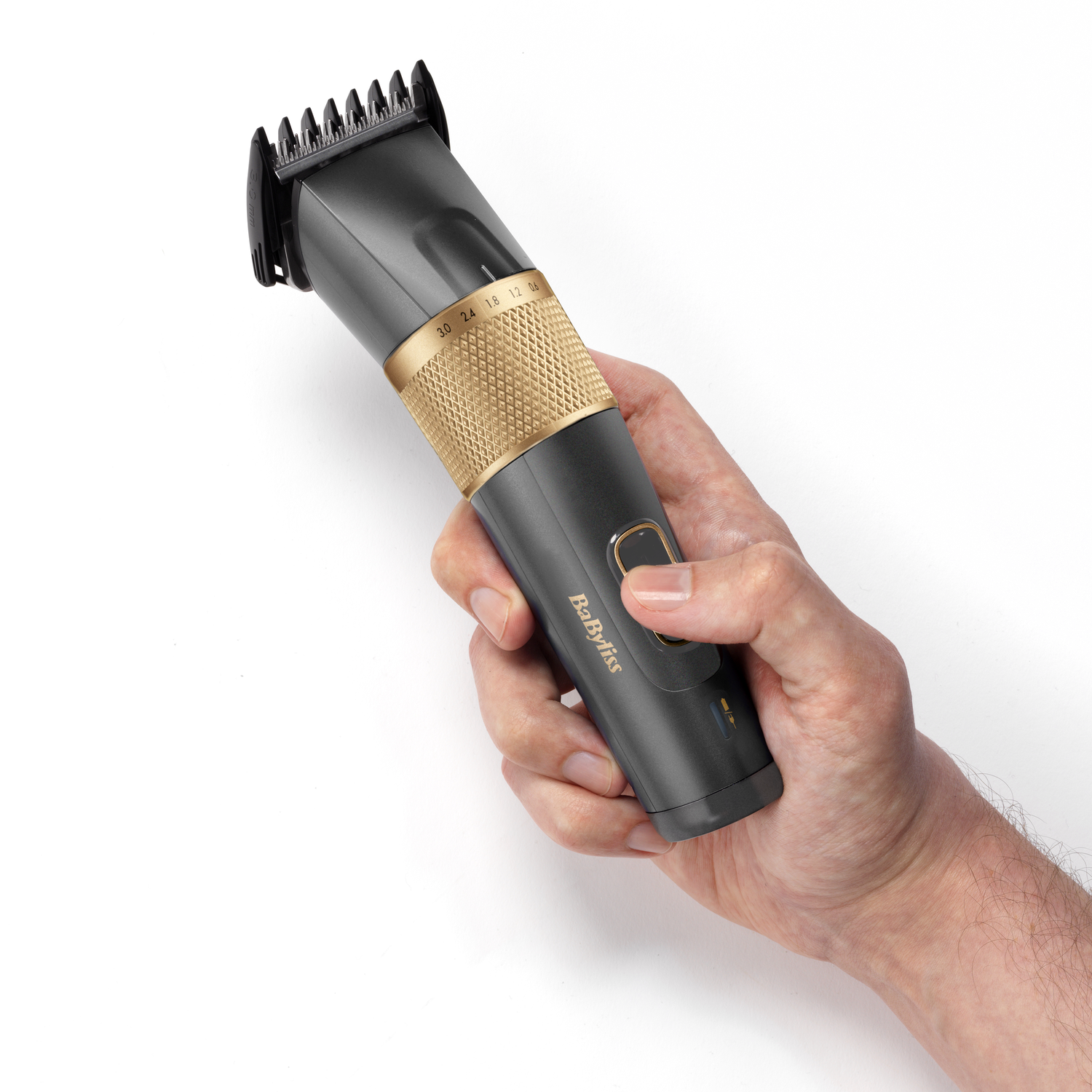 A hand holding a black and gold hair clipper, showing the cutting blade and settings.