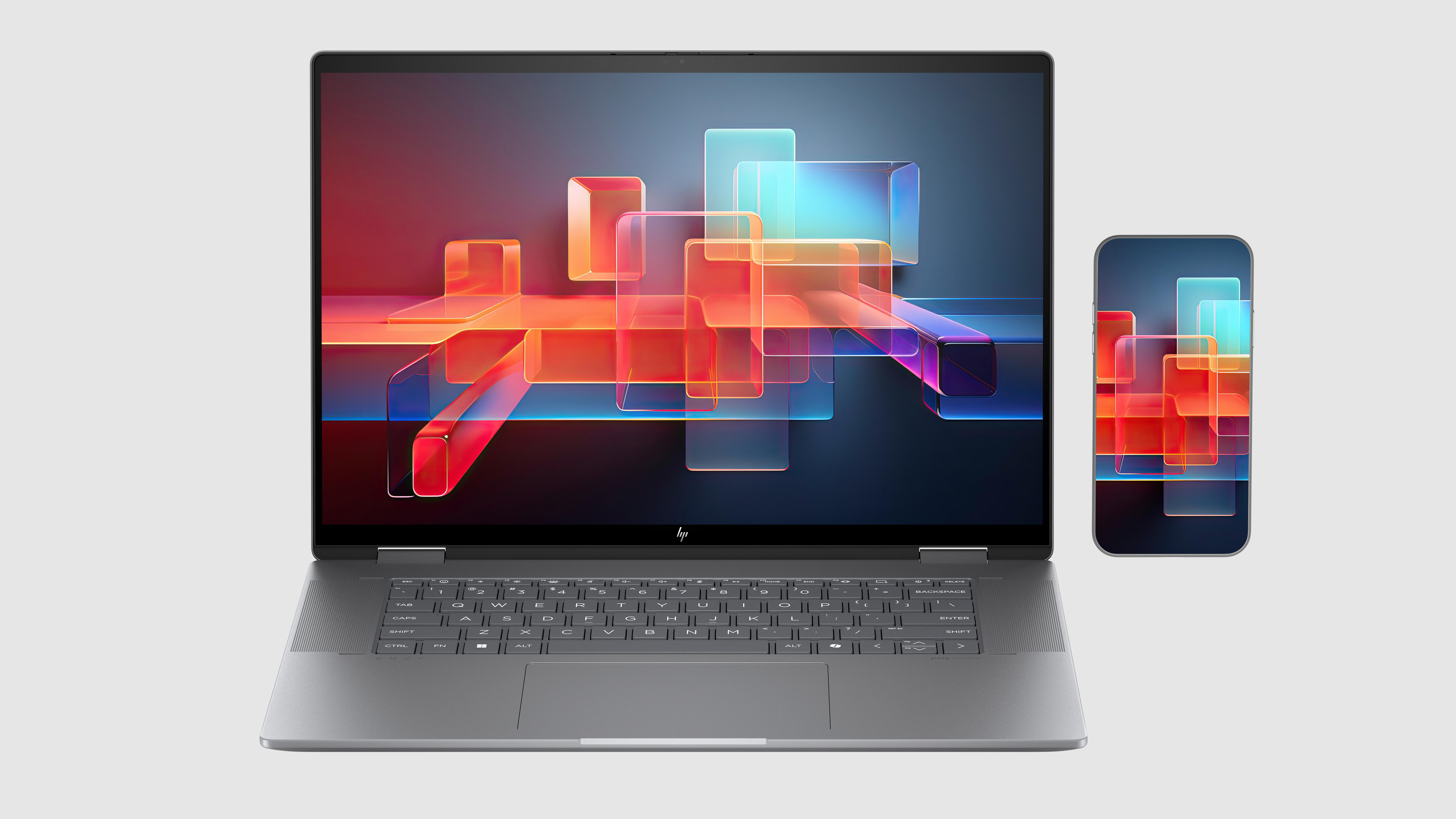 Laptop und Telefon auf hellem Hintergrund. Laptop-Bildschirm zeigt farbenfrohe Formen.