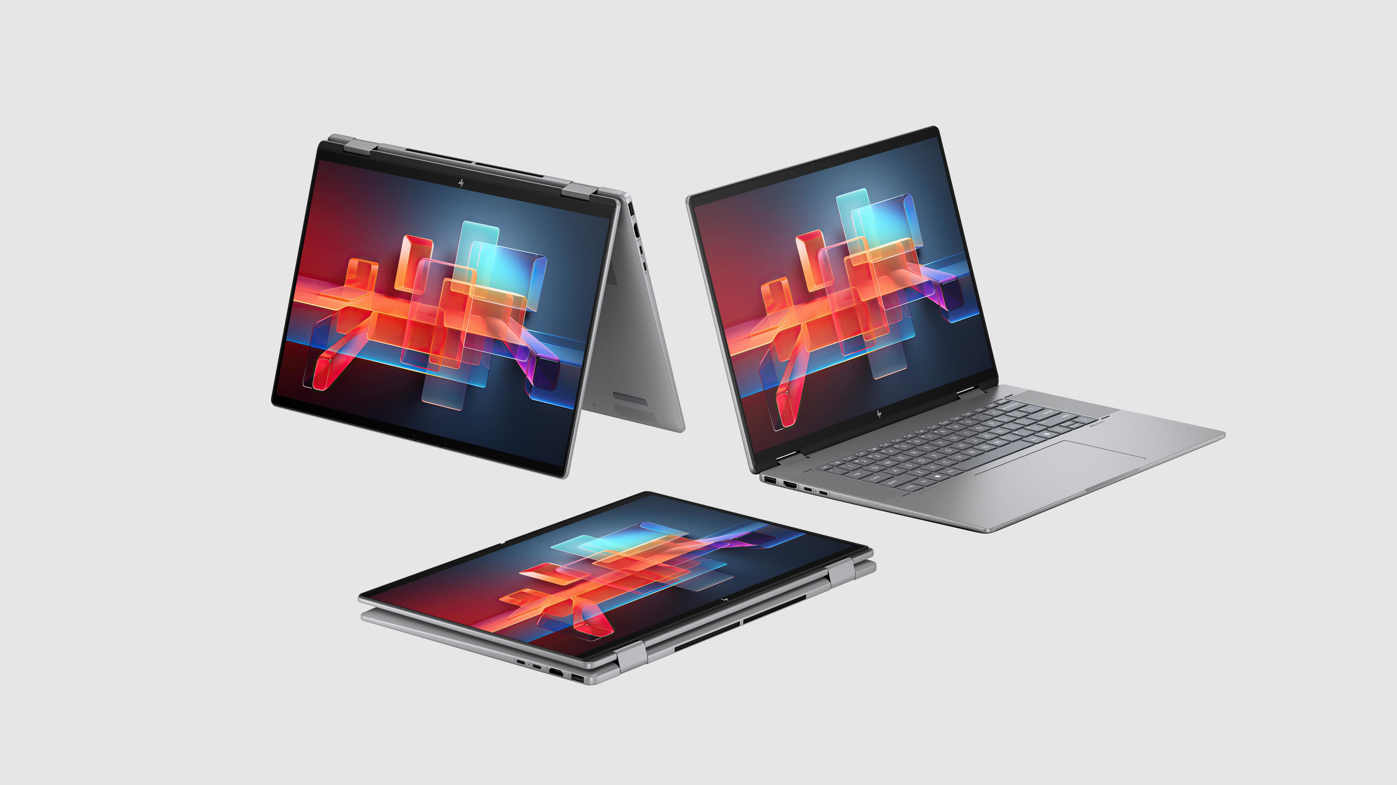 Drei silberne Laptops. Zwei mit farbenfrohen Bildschirmen geöffnet, einer geschlossen. Alles auf grauem Grund.