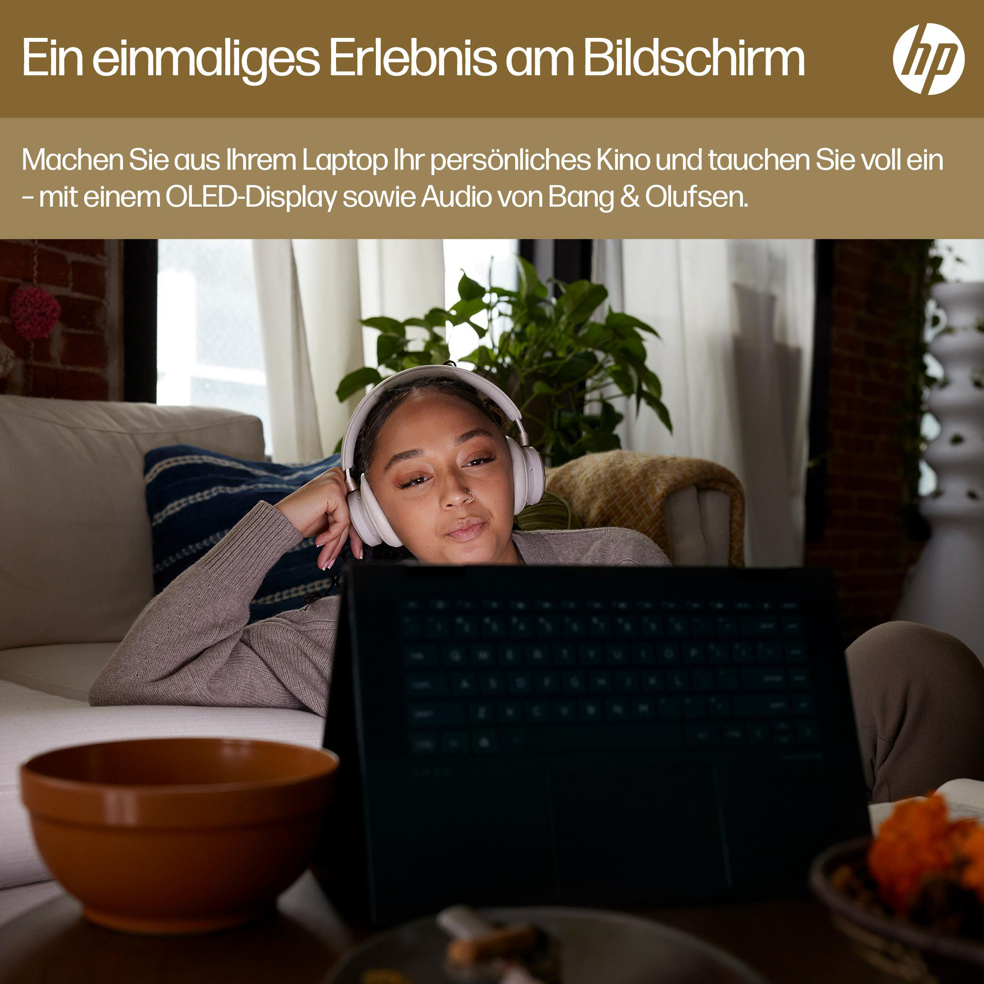 Frau mit Kopfhörern, die auf einen Laptop-Bildschirm schaut, mit Tisch und Pflanzen im Hintergrund.