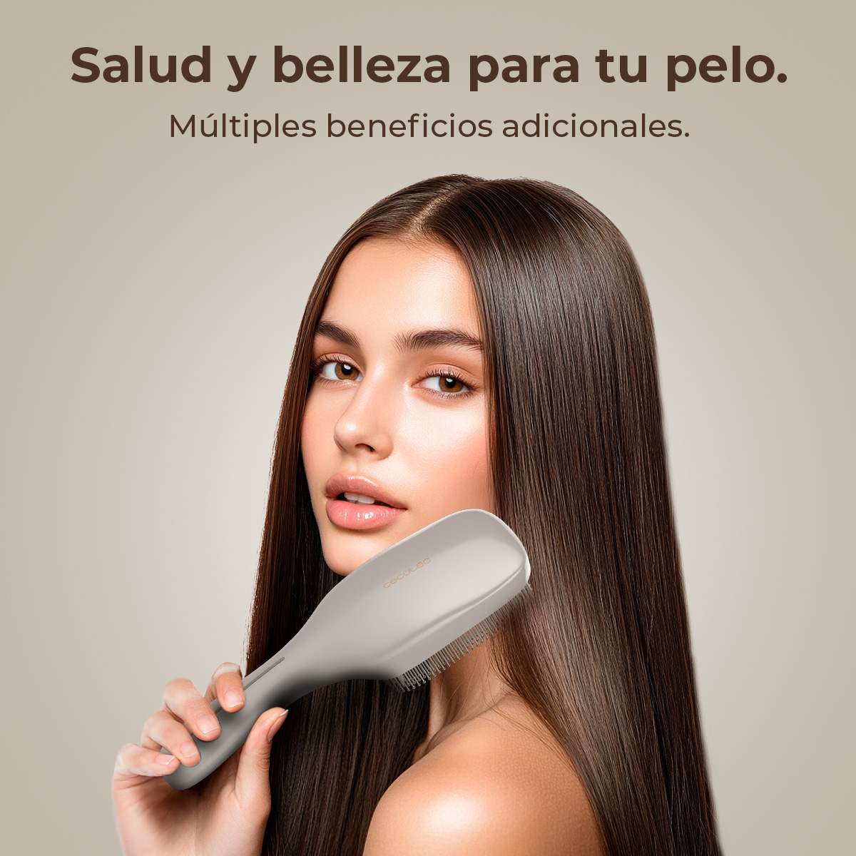 Una mujer sostiene un cepillo gris, sonriendo. El fondo es borroso y marrón claro. Tiene pelo largo y castaño.