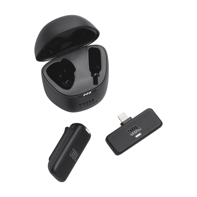 Auriculares JBL negros, estuche de carga y una pequeña base de carga negra sobre fondo negro.