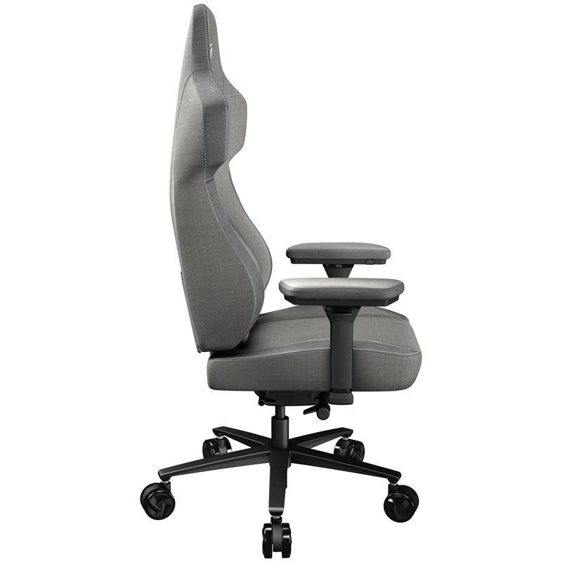 Grauer Gaming-Stuhl von der Seite. Er hat Armlehnen und eine Kopfstütze, schwarzes Untergestell mit Rollen.