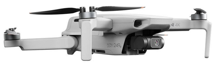 Biały dron z czarnymi śmigłami, kamerą i podwoziem. Jest w widoku z boku.