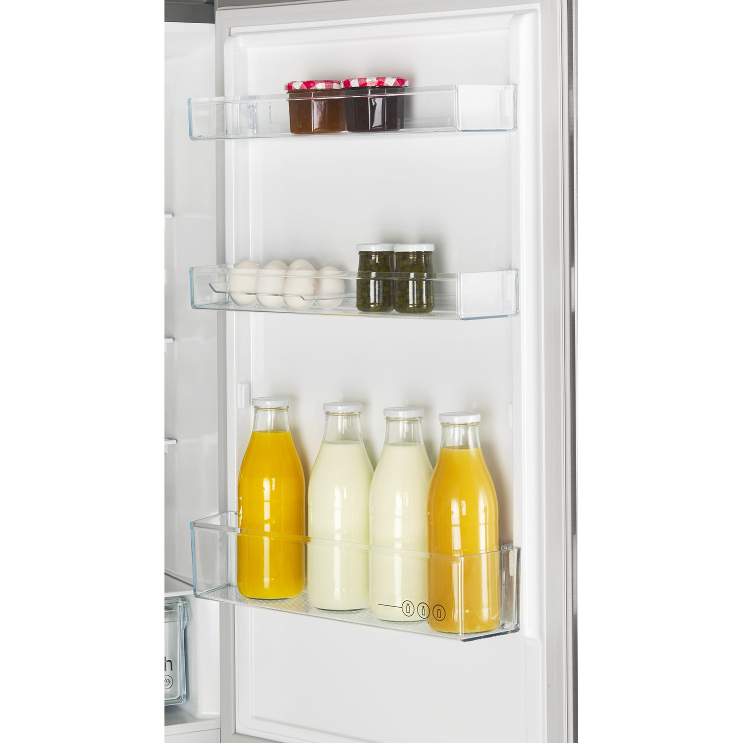 Interieur van de koelkast met planken met eten en drinken.