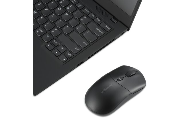 Laptop és egy fekete egér fehér felületen. A laptop nyitva van, az egér a jobb oldalán.