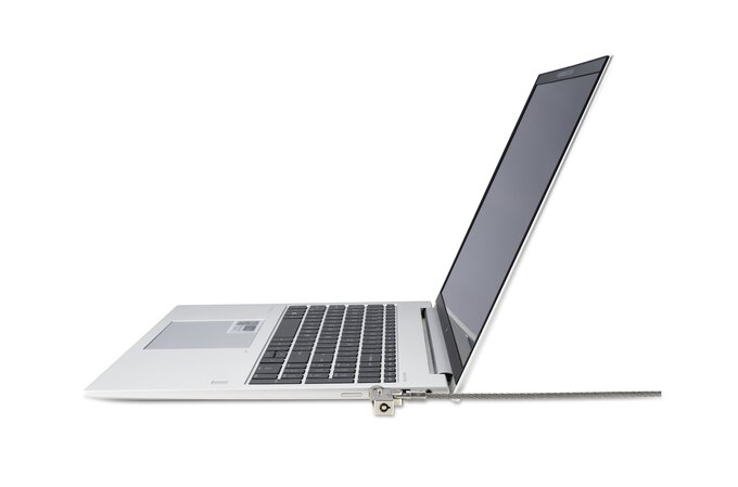 Egy ezüst laptop kábeles zárral rögzítve, fehér háttér előtt.