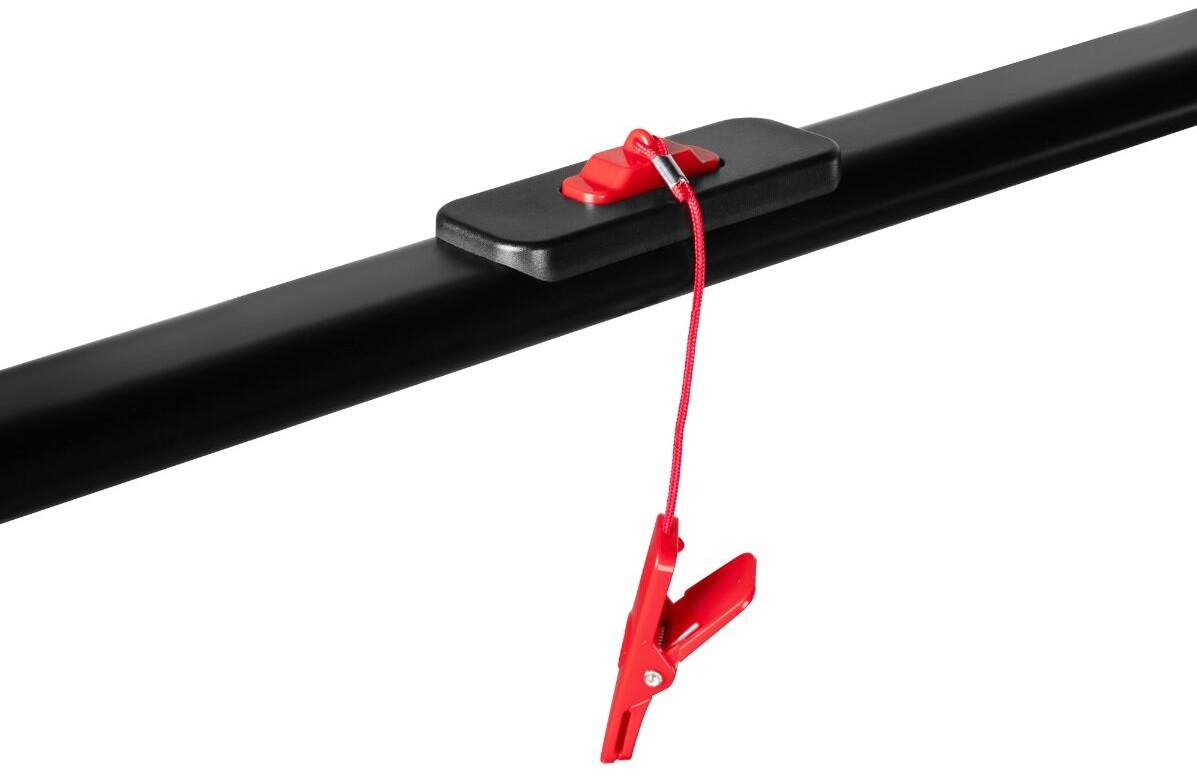 Czarny pręt z czerwoną spinką i sznurkiem przymocowanymi do czarnego prostokątnego elementu na białym tle.
