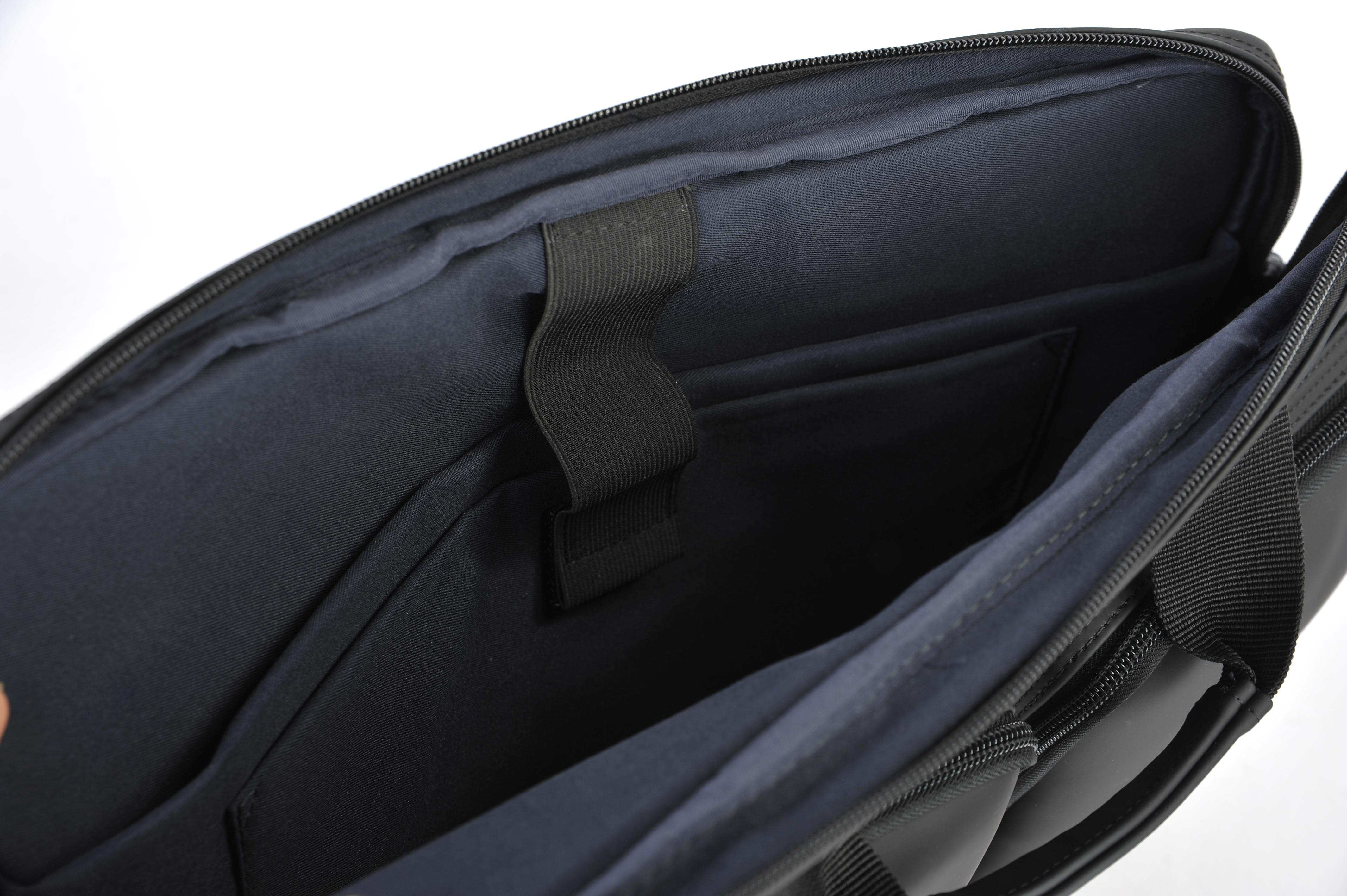 Innenraum einer offenen schwarzen Aktentasche mit Taschen und einem schwarzen Gummiband.