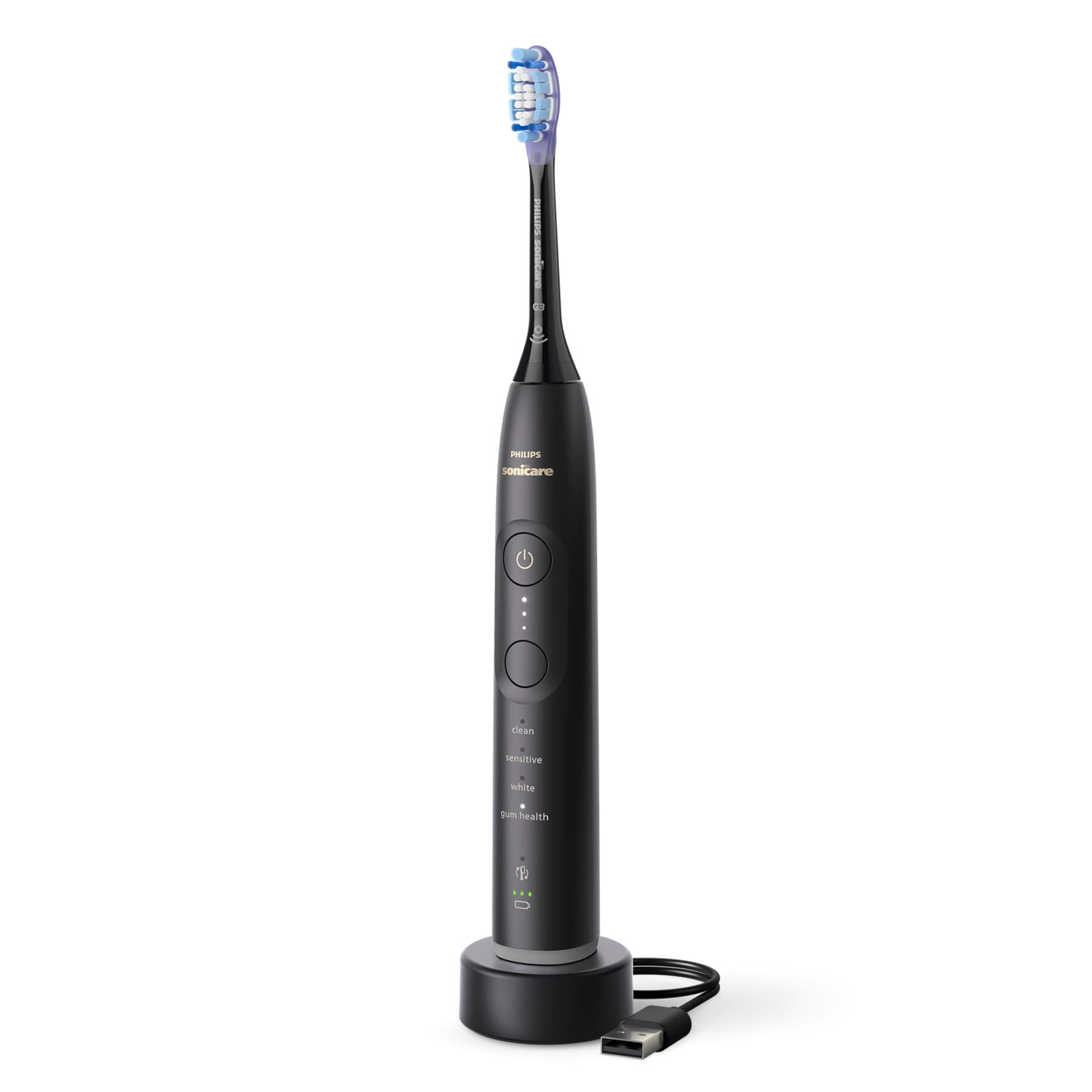 Brosse à dents électrique noire, sur une base de chargement. Câble USB connecté. Fond blanc.