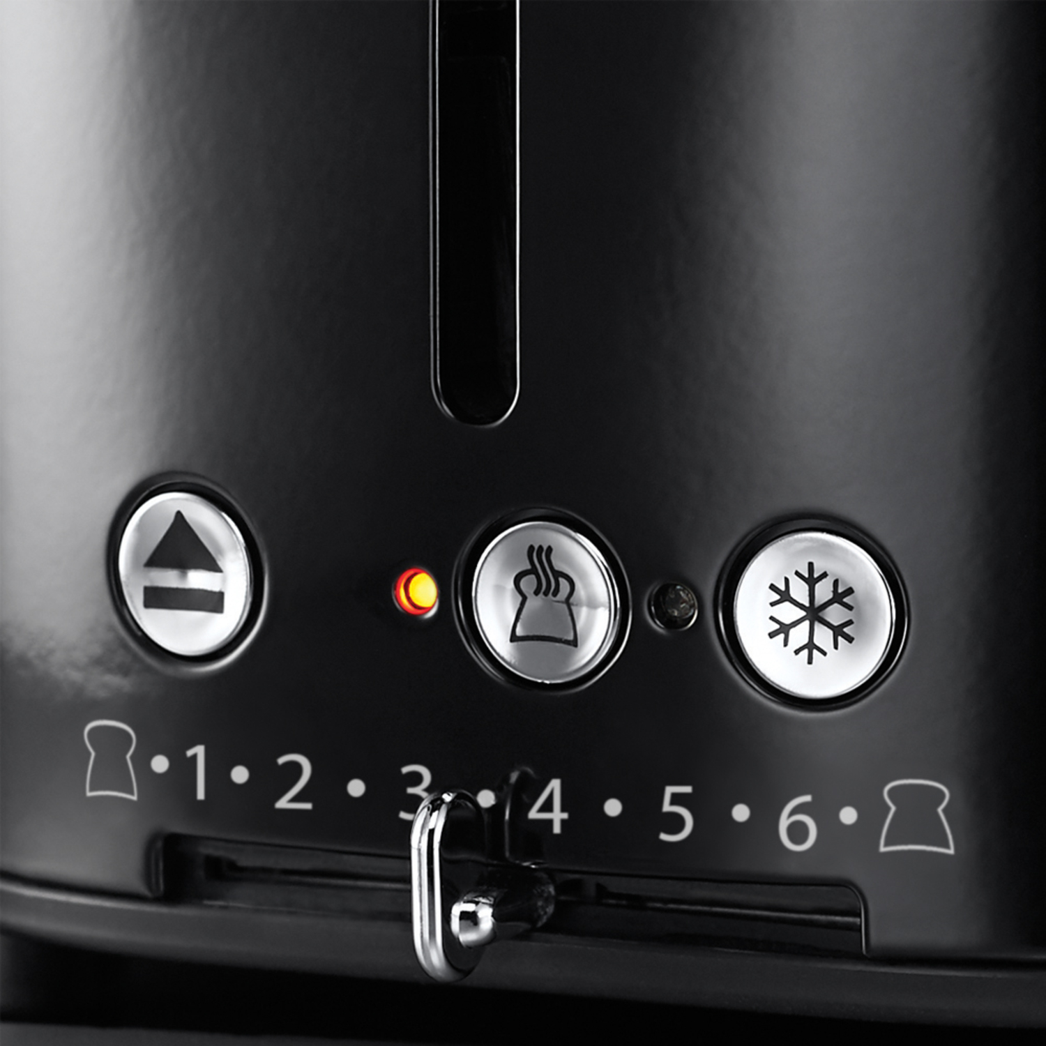Black toaster close-up, showing settings dial with numbers, buttons and an orange light.