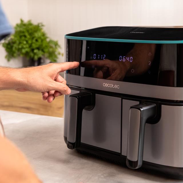 Személy keze az air fryer kijelzőjére mutat. Konyhai környezet.