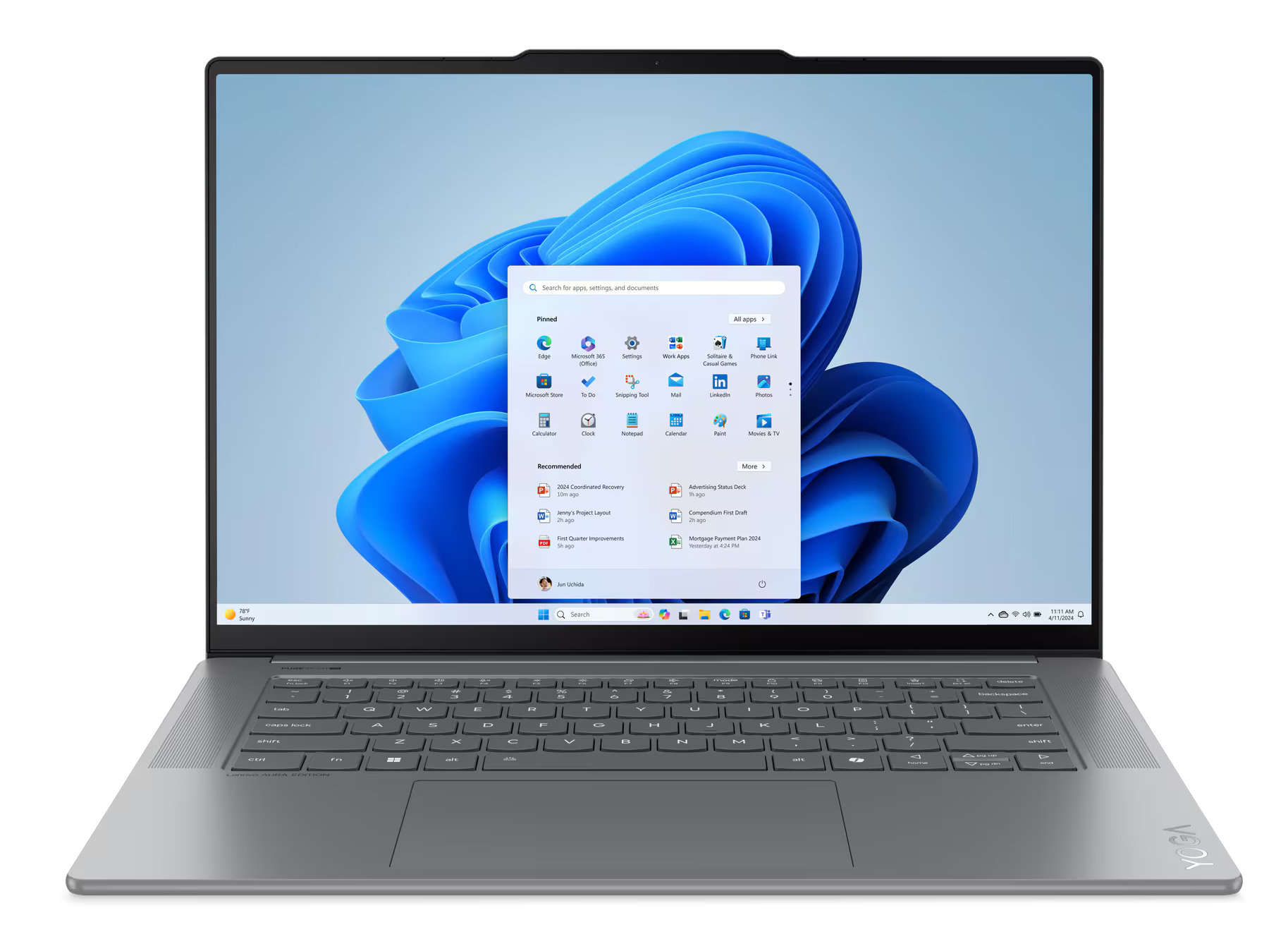 Srebrny laptop z interfejsem Windows 11 na ekranie, otwarty, pokazujący aplikacje.